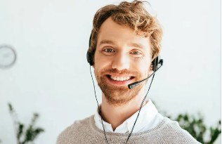 Conseiller du service client au casque téléphonique souriant au bureau